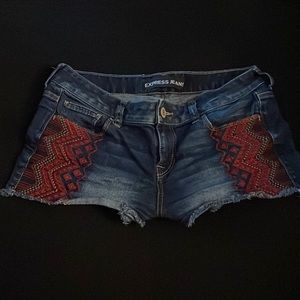 Express jeans washed dark denim, embroidered  tribal pattern pockets.